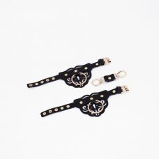 Черные кожаные наручники с клепками, кольцами и золотистой фурнитурой Черные кожаные наручники с клепками, кольцами и золотистой фурнитурой